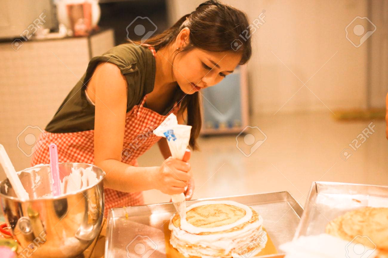 ¿Dónde puedo encontrar imágenes premium de mujer haciendo pastel?