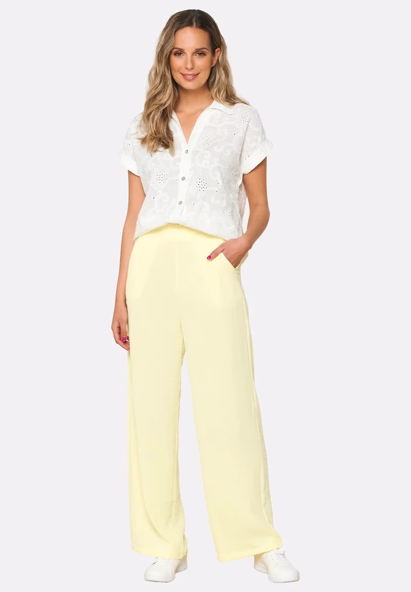 ¿Cómo combinar pantalones acampanados fluidos con leggins amarillos?